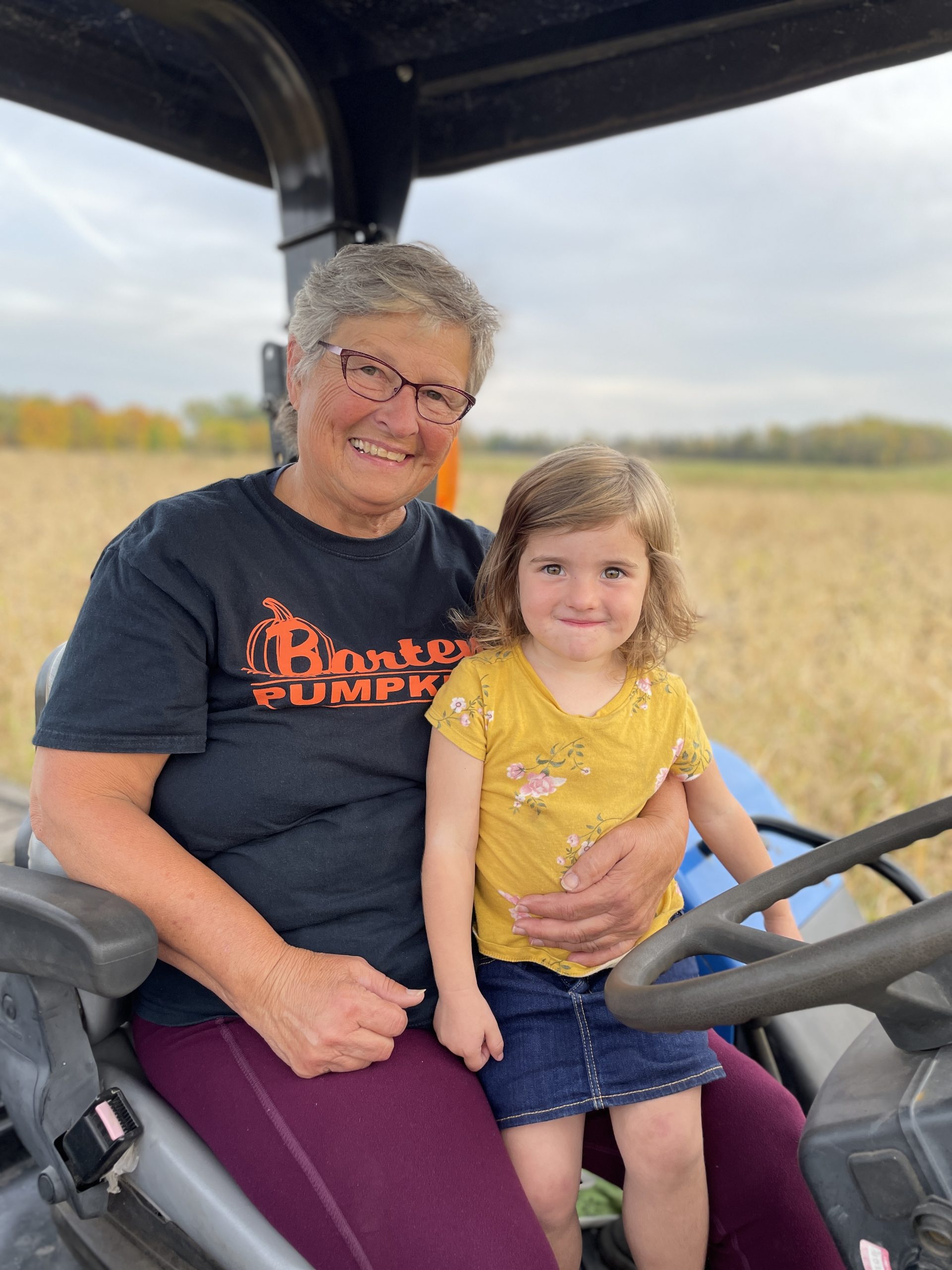 Grandma with Granddaughter Sitting in a Tractor